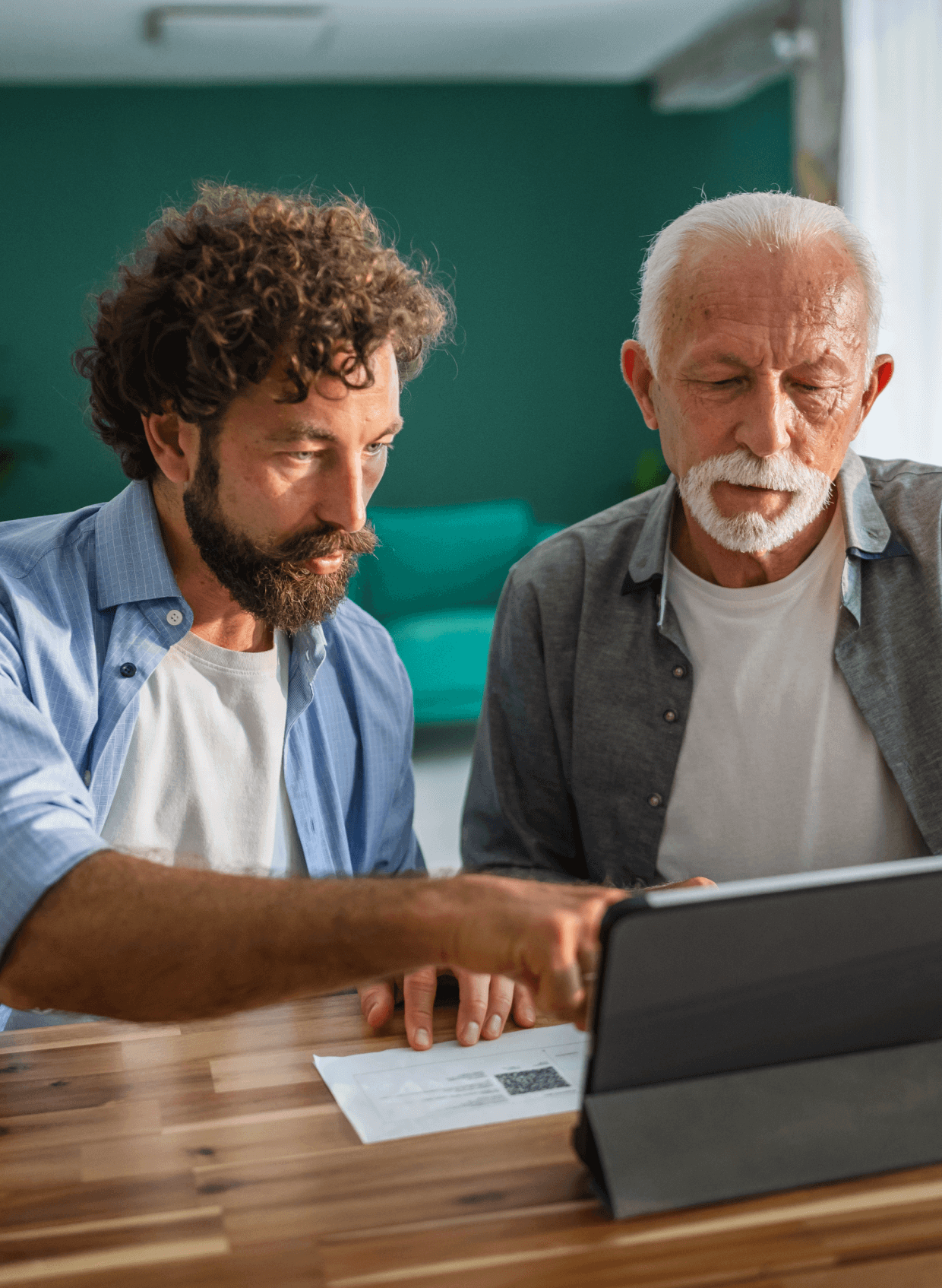 Two men using a tablet together.